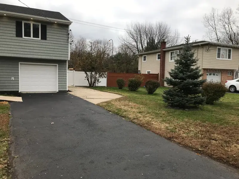 Renovated raised ranch with gray siding and a new driveway, Islip, NY